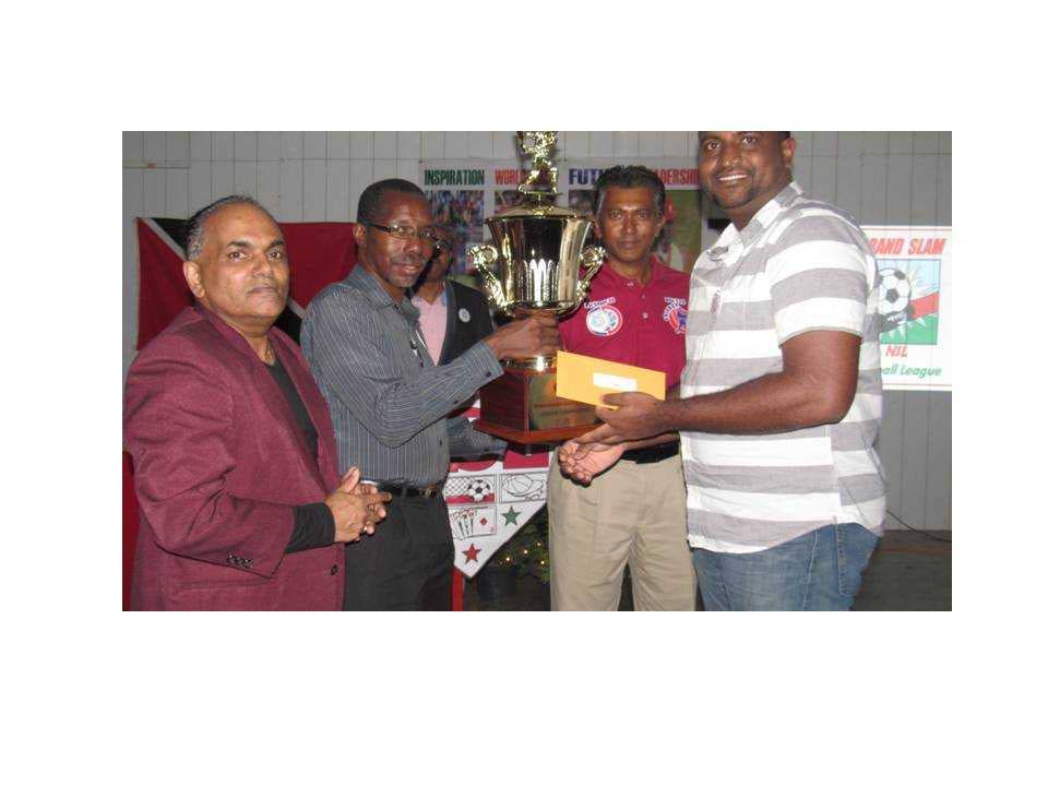 TROPHY TIME... and NSL director of sport  Paul Charles, hands over the  trophy to T20  champions Spoilers’ captain  Mukesh Boodoosingh watched by  league president from left Lincoln Persad and chairman Terry Gangoo.