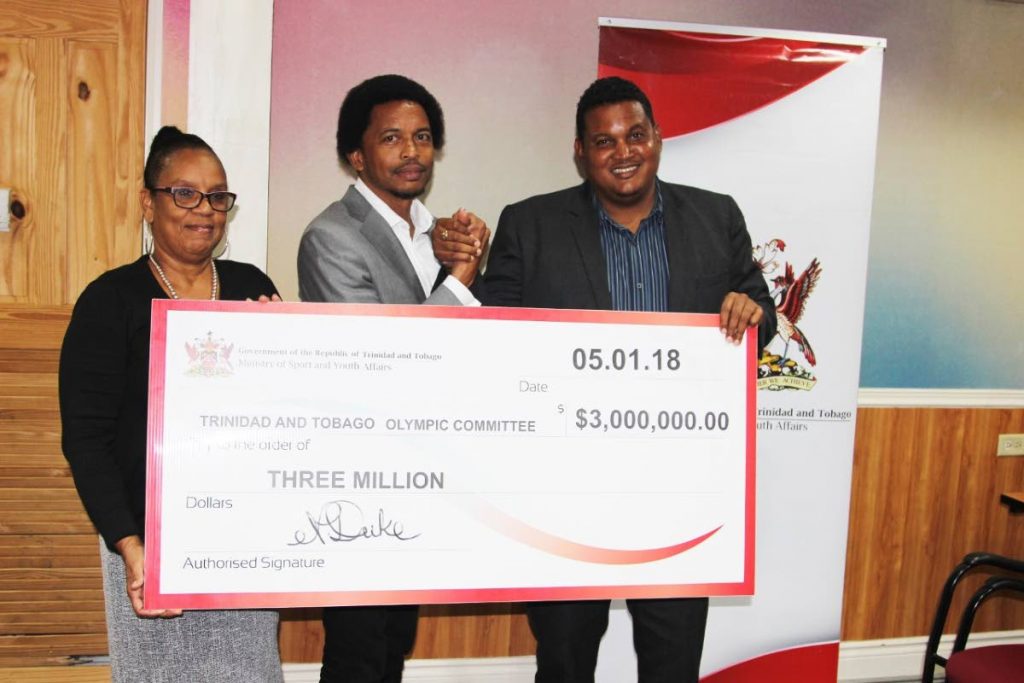 TEAM FUNDS: TTOC general secretary Annette Knott, left, and TTOC president Brian Lewis, centre, are presented with the ceremonial cheque by Minister of Sport and Youth Affairs Darryl Smith at Olympic House, Port of Spain recently.