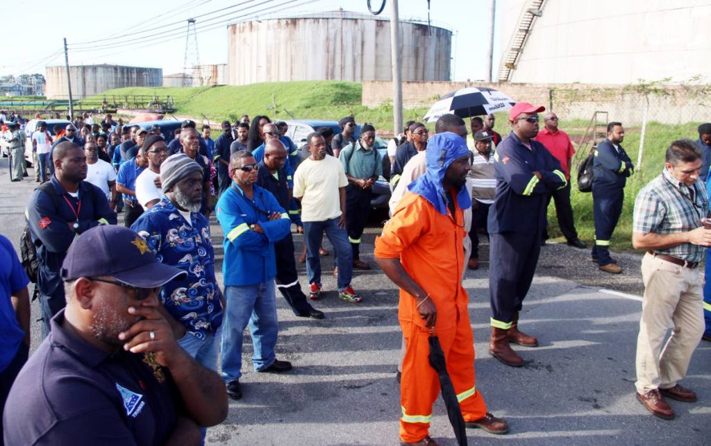 Trinmar workers listen to OWTU president Ancel Roget outside the company’s gates yesterday.