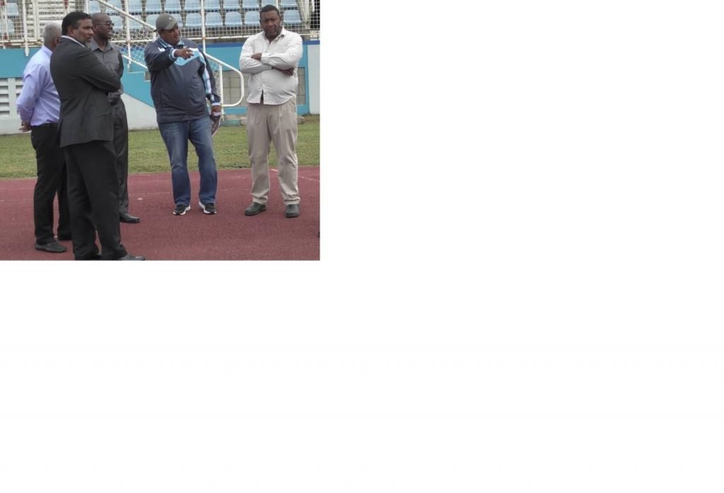 Sports Minister Darryl Smith, second from right, makes a point during a visit to the Ato Boldon Stadium in Couva yesterday. He is joined by TTFA boss David John-Williams, right, Sport Company Chairman Dinanath Ramnarine, left, and other officials.