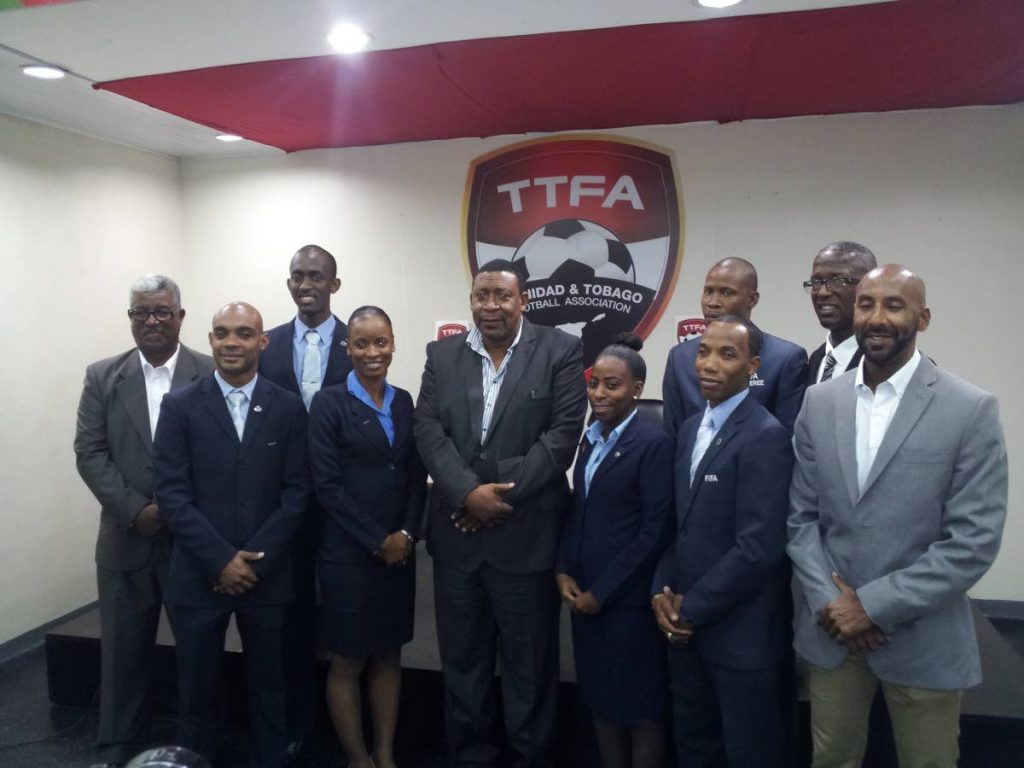 President of the TT Football Association David John-Williams, centre, poses with local referees and local referee administrators at the Ato Boldon Stadium in Couva, recently.