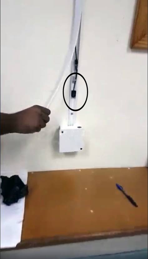 DISCOVERED: A freeze frame taken from a video posted to social media shows a Plipdeco worker pulling back the face strip of electrical trunking to reveal hidden inside, a micro camera, (circled). Three of cameras were found in a room used by female employees to change.