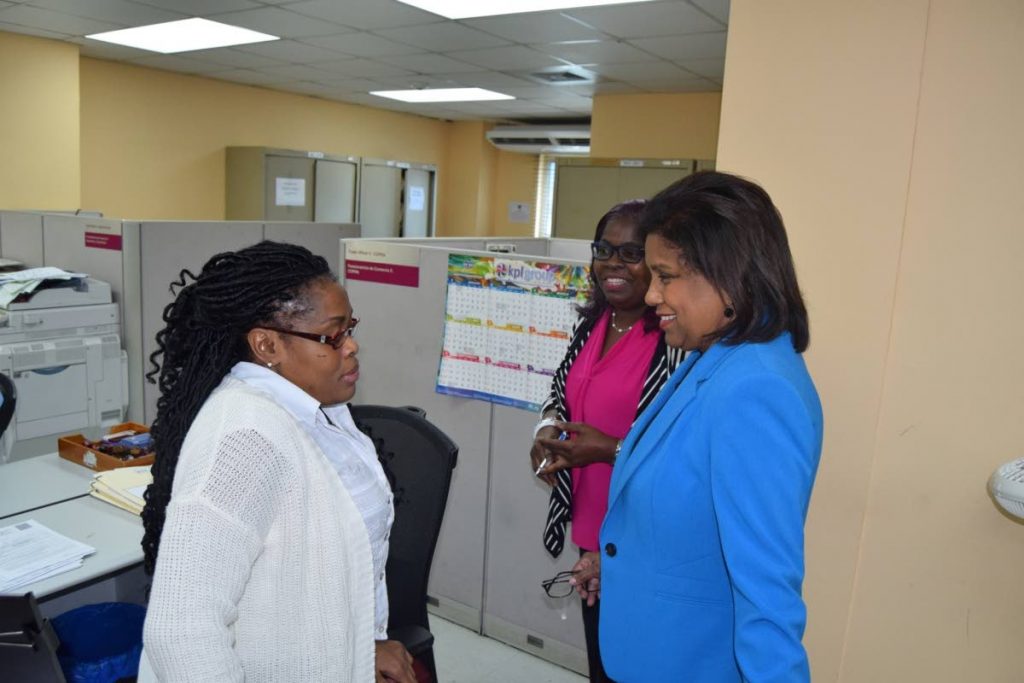 KEEP UP THE GOOD WORK: Trade and Industry Minister Paula Gopee-Scoon, right, with staff members of the Ministry’s Trade License Unit.