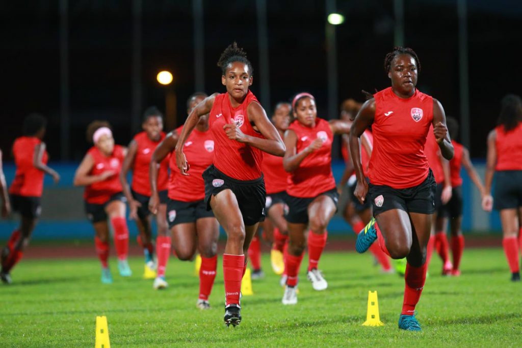 TT’s Under-20 players Brittney Williams (front left) and Natisha John (front right) sprint in a warm-up exercise on Sunday at the Ato Boldon 
Stadium, Couva.