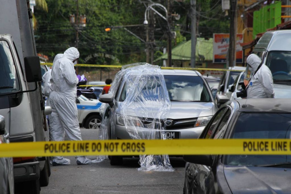 FILE PHOTO: Investigators process the scene of a shooting incident on Queen Street, Port of Spain.