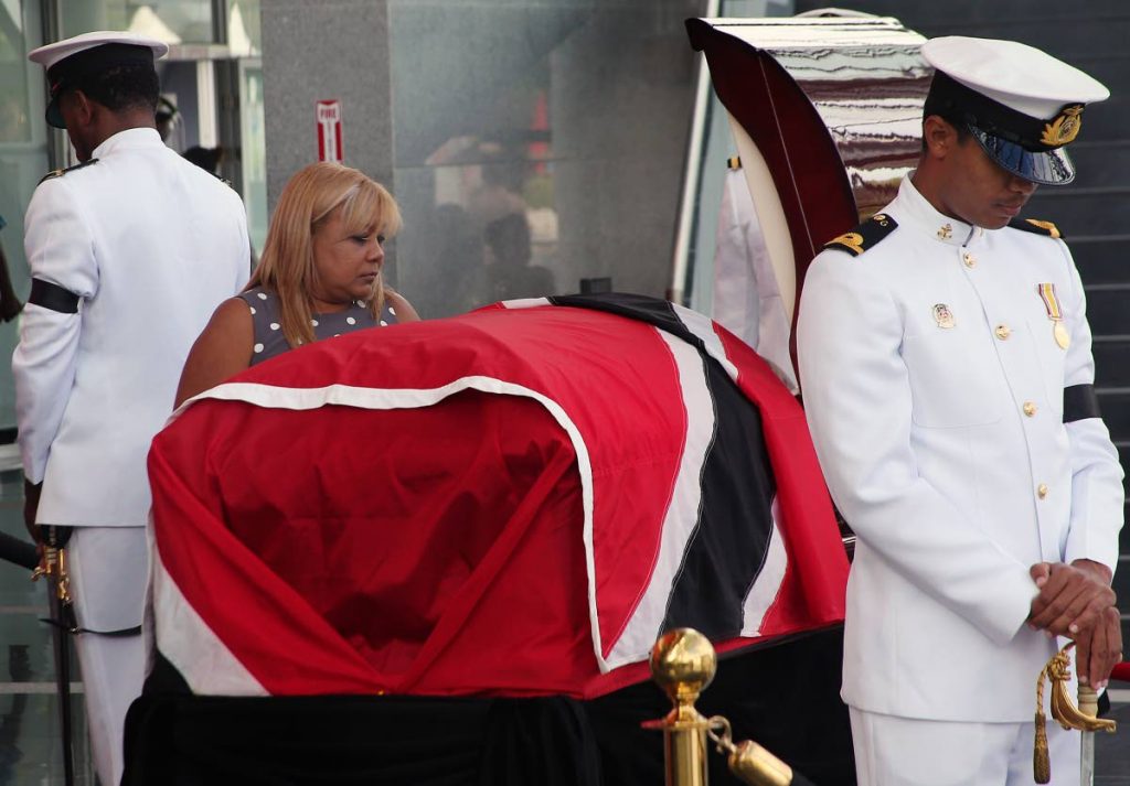 MISSING DADDY:Maxine Richards looks at her father, former president George Maxwell Richards, as his body lies in state at NAPA in Port of Spain yesterday. Richards' funeral will be held today at the same venue.