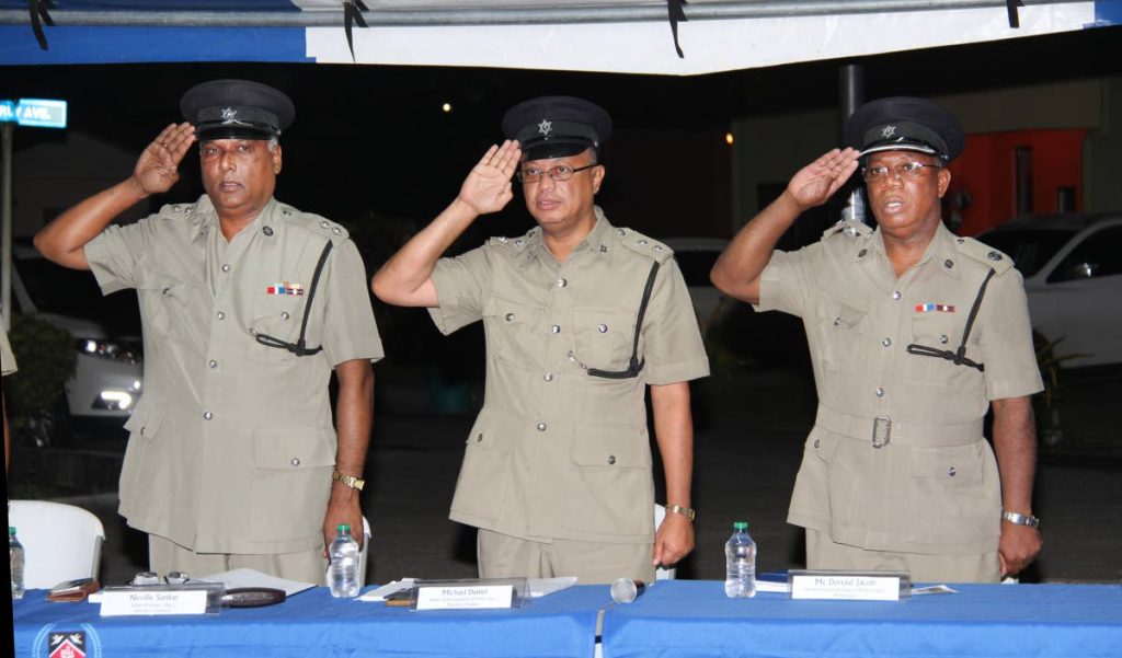 SALUTE: (from left) Supt Neville Sankar, Snr Supt Michael Daniel and ACP McDonald Jacob at Wednesday’s police town meeting at Greenvale Park, La Horquetta. PHOTO BY SUREASH CHOLAI