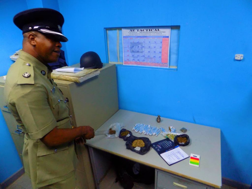 Superintendent Glenn Charles of the Port of Spain City Police displays 410 g of marijuana seized during a raid at a Port of Spain City Corporation Office on Wednesday. 