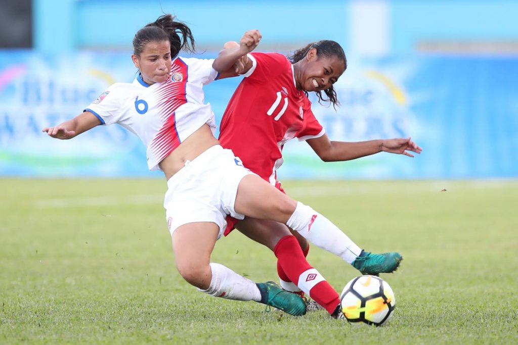 Costa Rican defender Maria Elizondo,left, is tackled by Canadian striker Jayde Riviere during action in the opening match of the CONCACAF U20 Women's Championships at the Ato Boldon Stadium, Couva yesterday. Canada won the match 3-1.