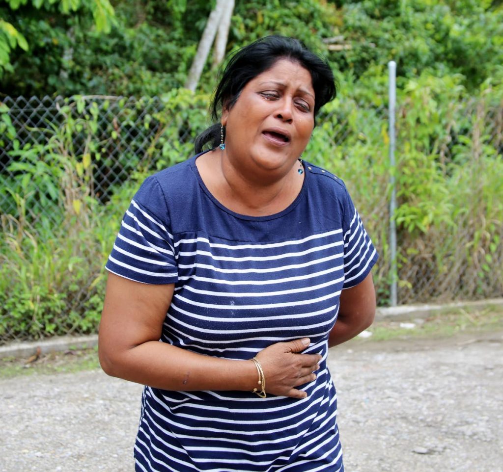 Nirmala Sieukaran weeps yesterday for a relative who is in police custody for questioning in the fatal stabbing of Dayanand  Dookie at Solomon Drive, Cunupia, on Friday.  Photo by Vashti Singh