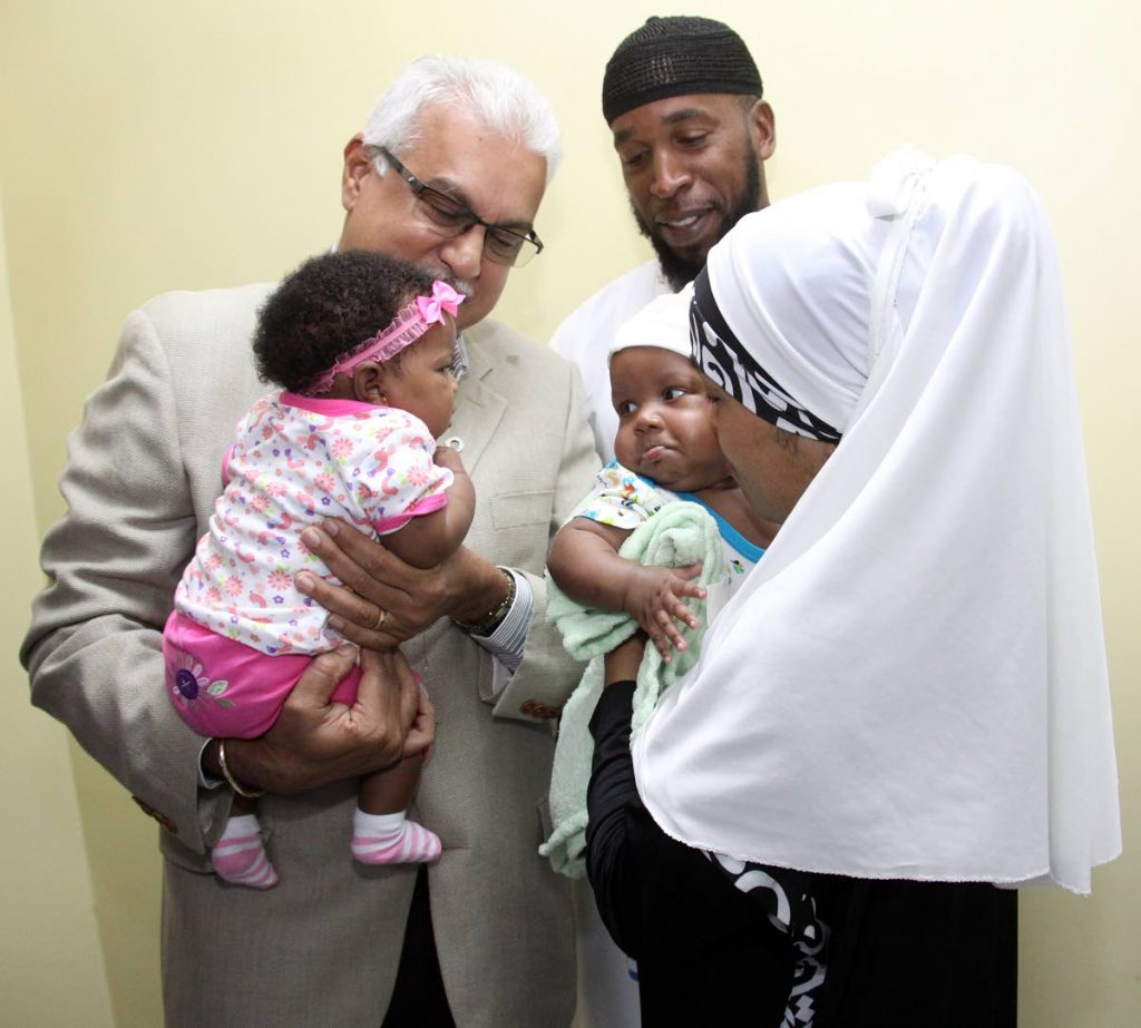 BABY TALK: Minister of Health Terrence 
Deyalsingh holds baby Imani, while Darwin John and Camay Diaz, 
parents of baby Ishmal, look on, 
at Mt Hope Maternity Hospital 
yesterday. Nurses will now make house calls on pregnant women.
