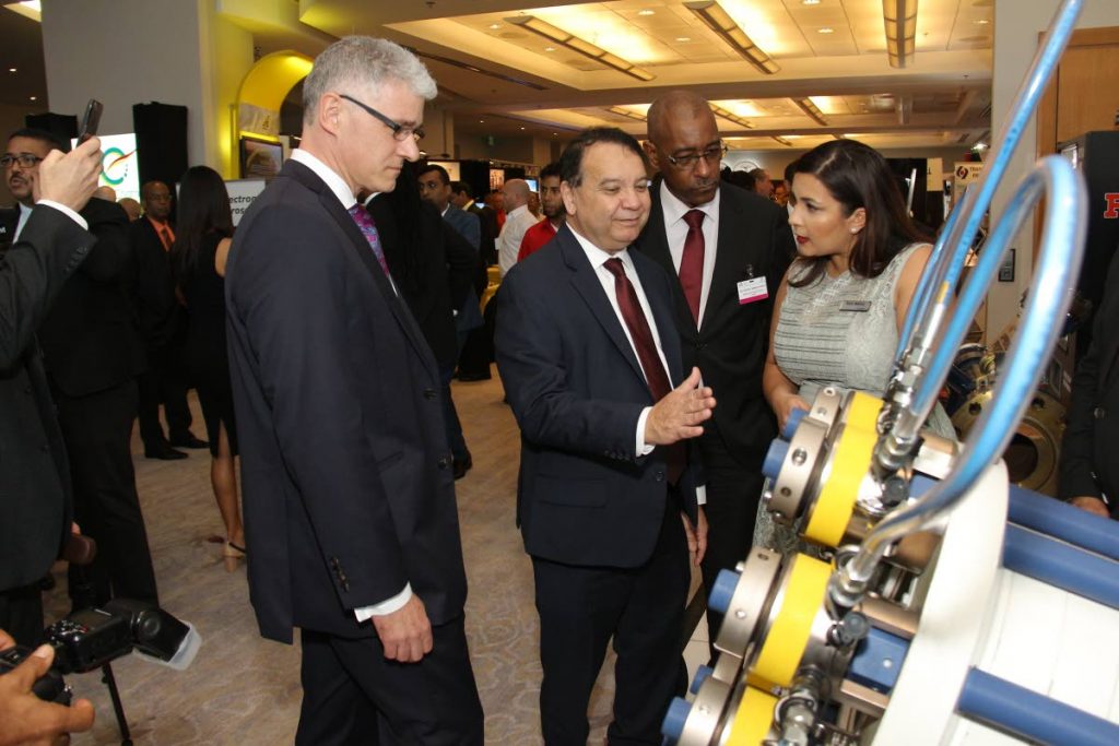 Rani Mahey EPRS Key Account Specialist with UK based company Hydratight Limited explains the use and function of their pipe line repair connector for use in the oil & gas industry to Minister of Energy and Energy Industries Franklin Khan also in photo is Dr Thackwray Driver President & CEO Energy Chamber TT (left) and Minister of Public Utilities Robert Le Hunte. Dumore Enterprises Ltd is the local distributor for this product on the first day of the 2018 Energy Conference at Hyatt on Monday January 22 2018. Photo by Jeff K Mayers