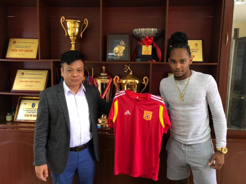 Neil Benjamin, right, and a Nam Dinh FC official proudly display the Vietnam V-League club’s jersey.