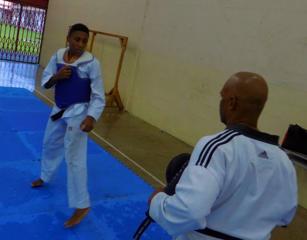 Junior TKD champ Jean Maurice Young, left, squares up against instructor Colin Mofford during a recent training session. 