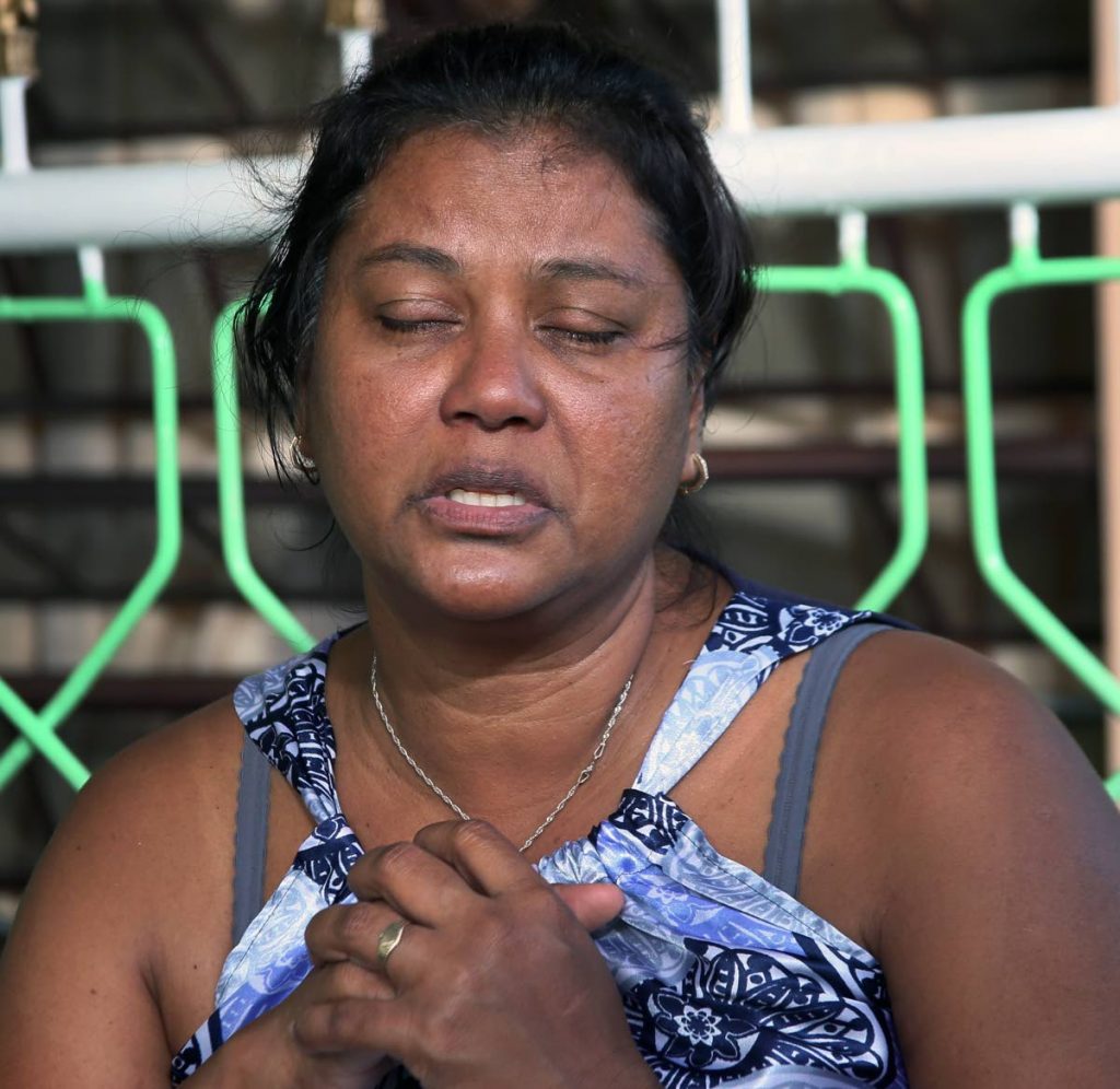 Wife's Pain: Asha Boodooram, the wife of murdered Prisons Officer Devendra  Boodooram, clutches her hands close to her heart telling Newsday how much it pains her heart following the senseless murder of her husband. Boodram was the father of two girls.
PHOTO BY AZLAN MOHAMMED]