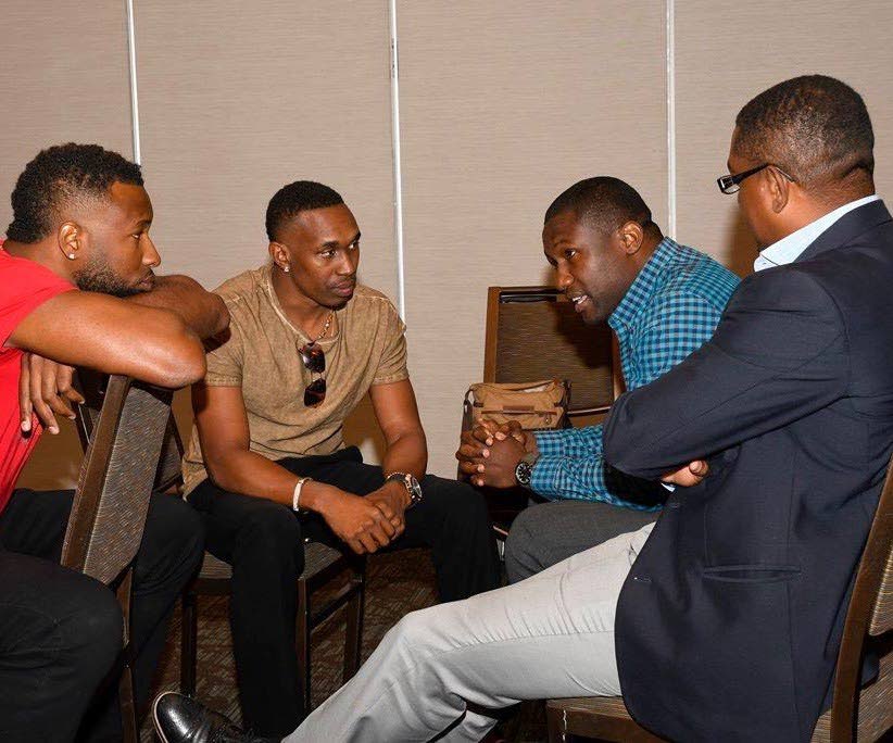 Cricket West Indies president Dave Cameron, right, chats with cricketers Kieron Pollard, left, and Dwayne Bravo, second from left, as well as West Indies Players Association head Wavell Hinds in an August 2016 meeting that has failed to resolve differences.