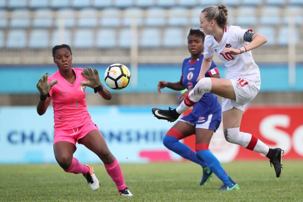 Canada’s Gabrielle Carle, right, shoots at goal as Haitian goalie Kerly Theus is alert to the danger in the 3rd/4th playoff yesterday at the CONCACAF U-20 Championships.
