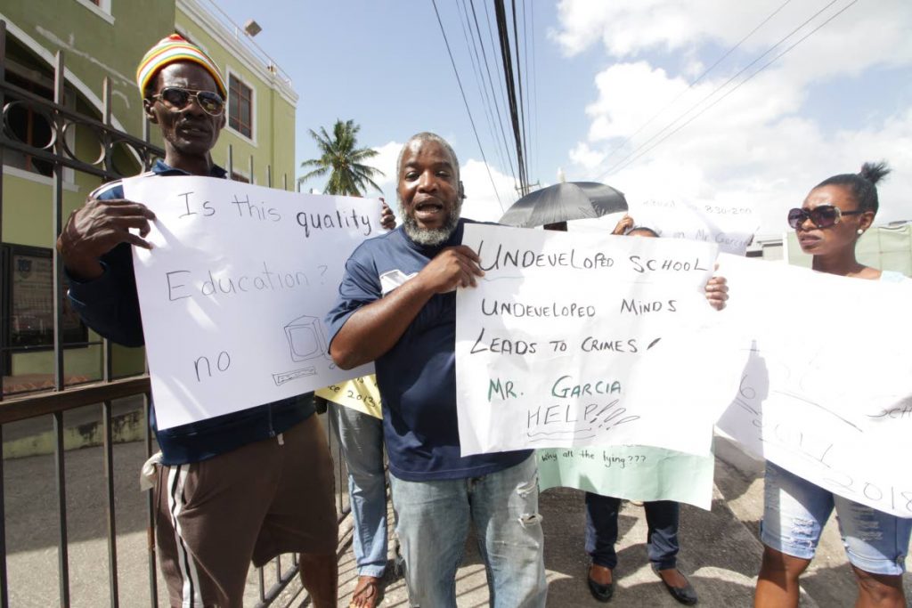 FED UP: Joel Scott (left), PTA president of the San Juan Government School, leads a protest outside the school’s temporary location at Eastern Main Road, Tunapuna yesterday.  PHOTO BY ROGER JACOB