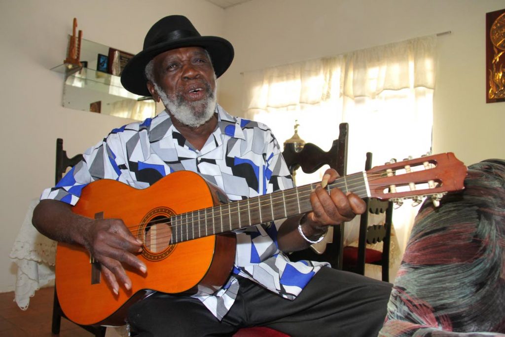 Shadow strums: Calypso icon Winston “Shadow” Bailey strums a tune at his home in thie December 4, 2015 file photo.