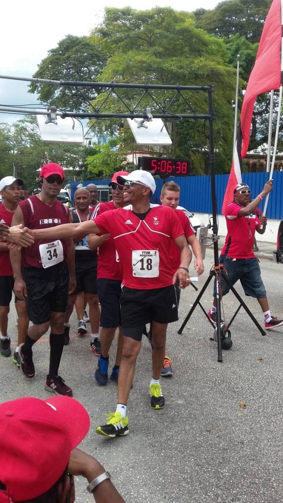 WALKING THE TALK: Brian Lewis, front, president of the Trinidad and Tobago Olympic Committee, is congratulated after finishing the TT International Marathon in January 2016.