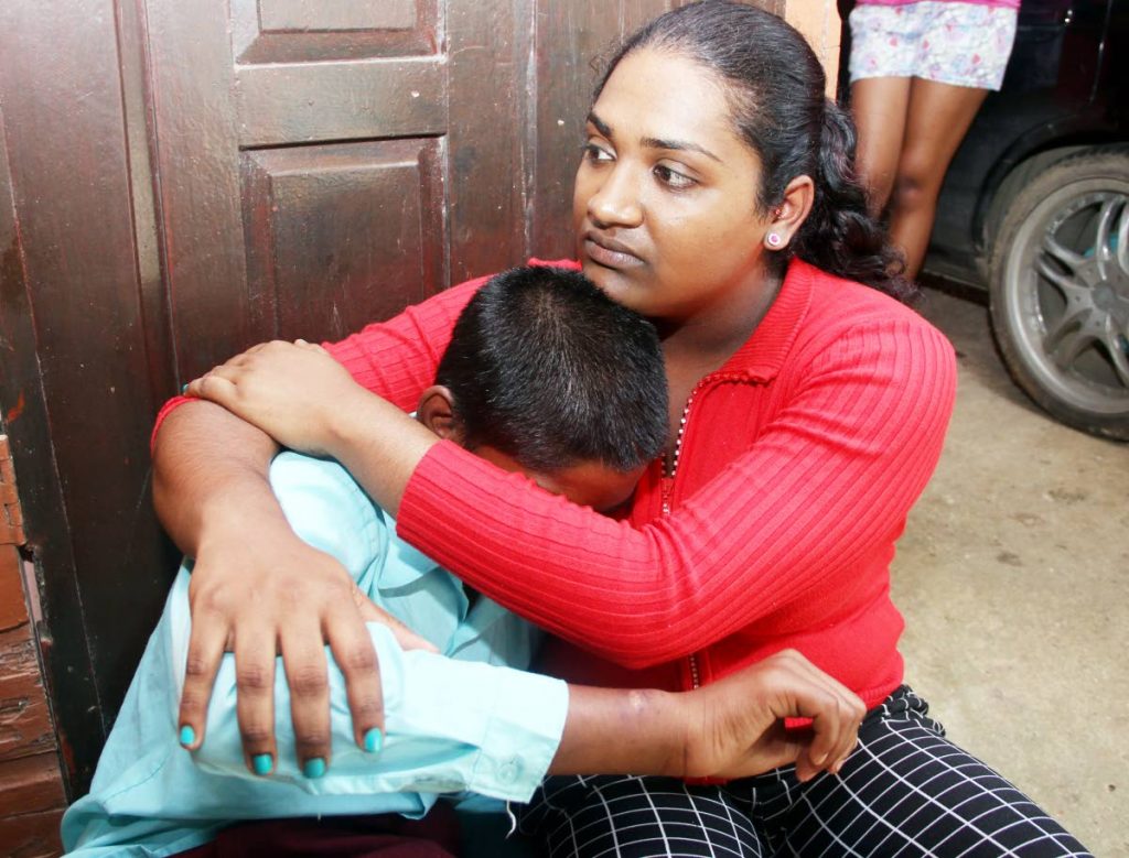  Faith Ramcharan comforts her neighbour who was rescued by the Children’s 
Authority after being subjected to months of abuse by relatives. Ramcharan alerted the authorities to the abuse she saw being meted out to the teen.