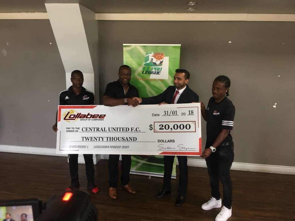 Sheldon Stephen, second from right, Director of Lollabee Group of Companies, hands over a $20,000 cheque to Stern John, second from left, coach of Central FC at a press conference on Wednesday at the VIP Lounge, Hasely Crawford Stadium, Mucurapo. Assisting in the presentation are Central FC players Darren Mitchell, right, and Keron Cummings.