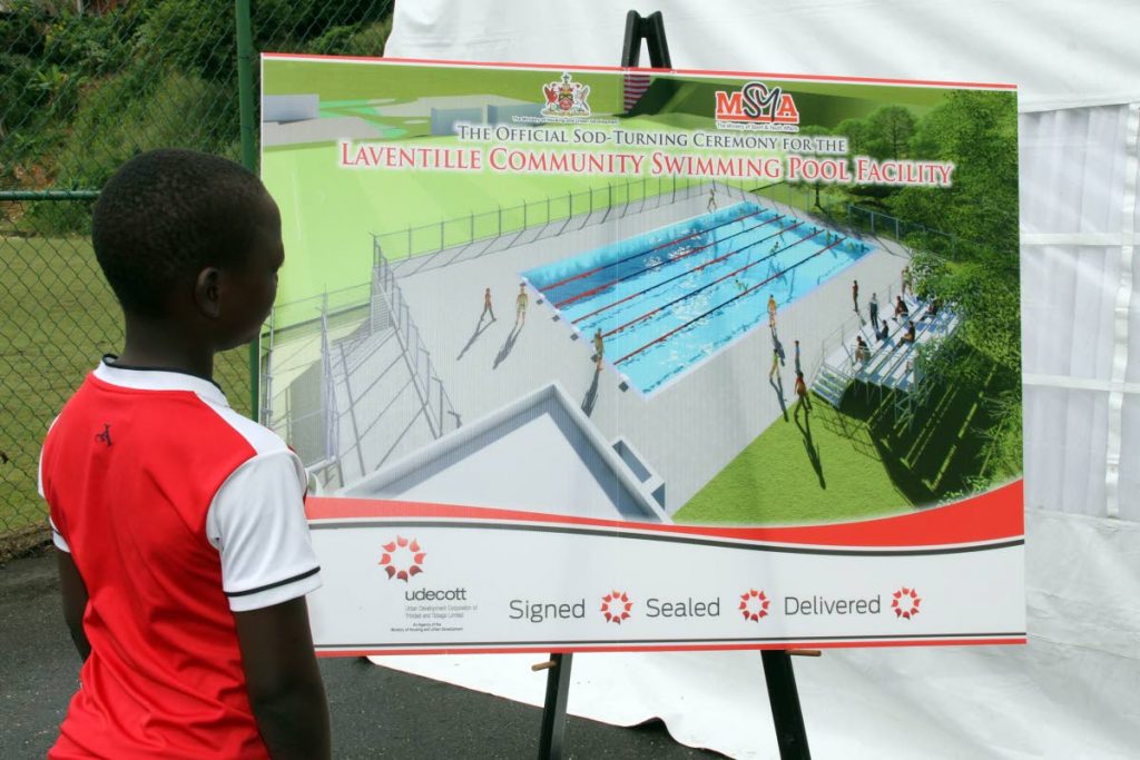 I’M READY: A boy looks at a sketch of the planned Laventille Community Swimming Pool Facility which is to be built and opened by August.    PHOTO BY SUREASH CHOLAI