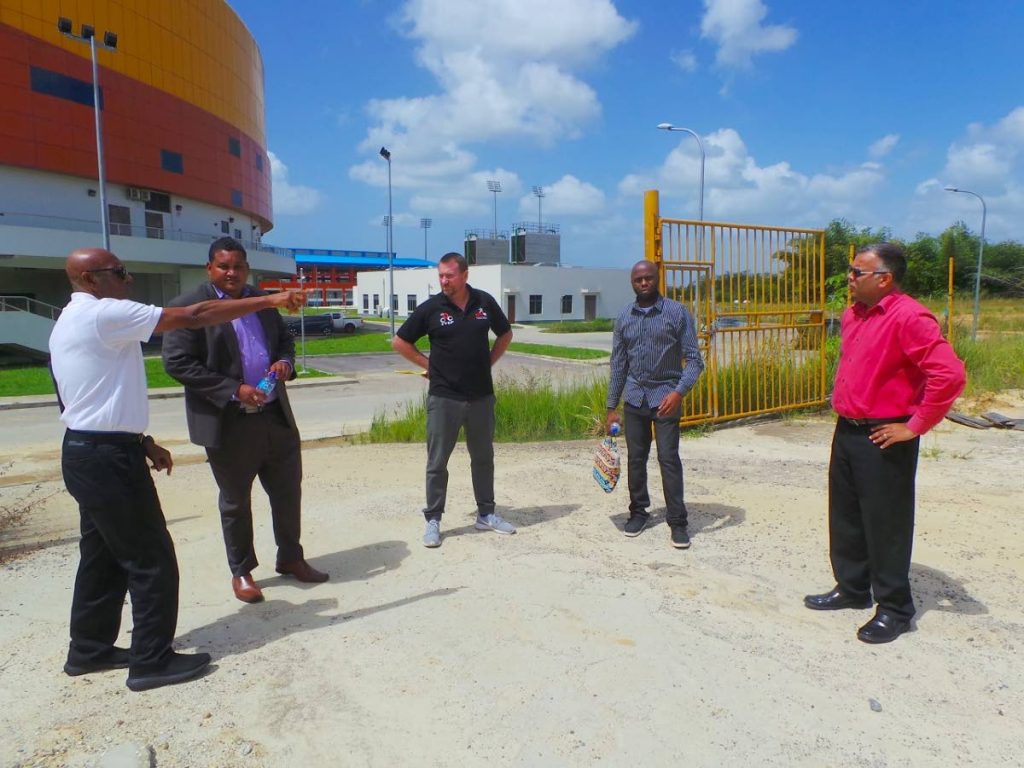 Anthony Creed points to a location on site behind the National Cycling 
Velodrome as Minister Smith, second from left, Erin Hartwell, centre, 
Trevlon Hall, second from right, and Jason  Williams look on.