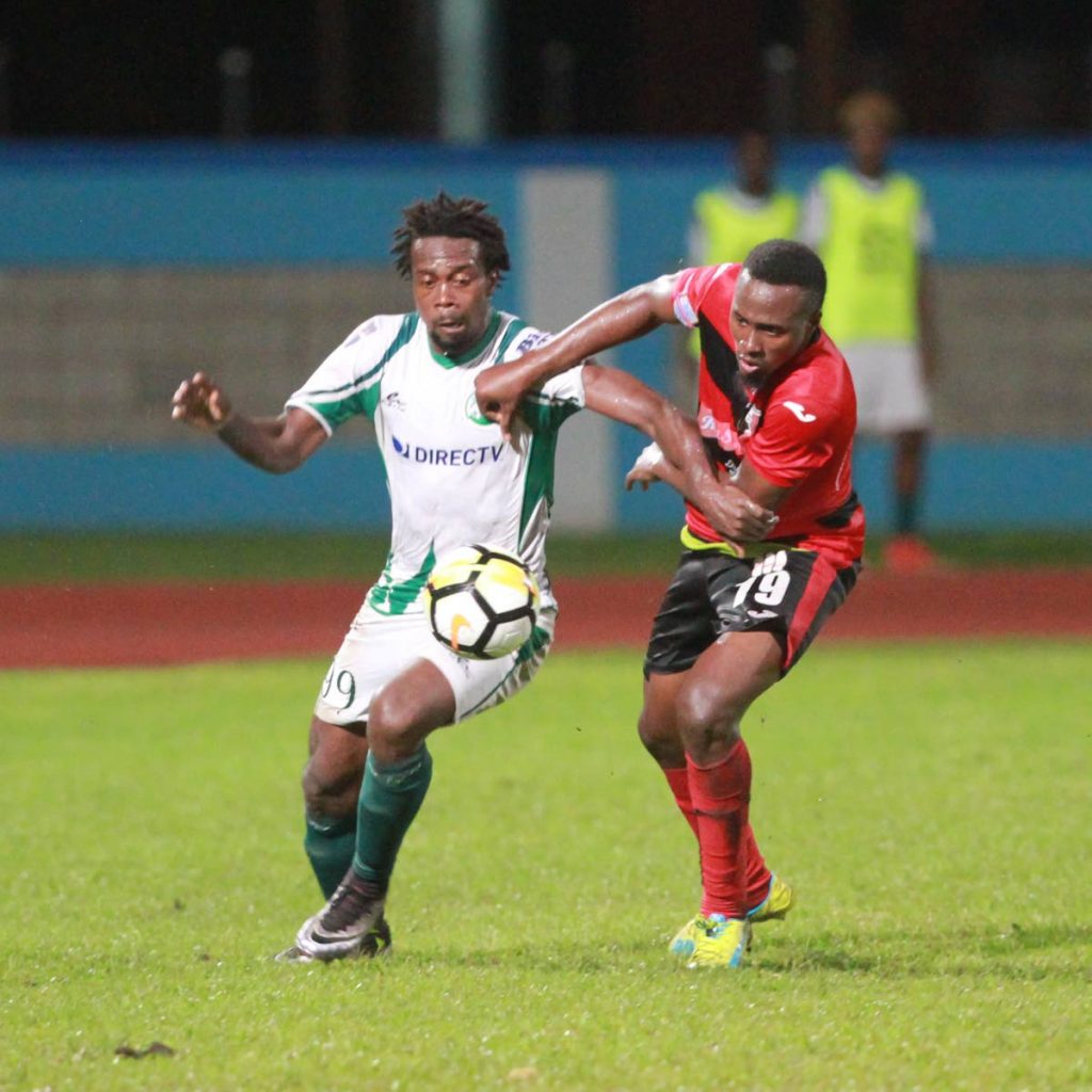 W Connection’s Marcus Joseph,left, vies for the ball with Arnett Gardens’ Tamar Edwards on Friday night at the Ato Boldon Stadium, Couva for the Flow CONCACAF Caribbean Club Championships.