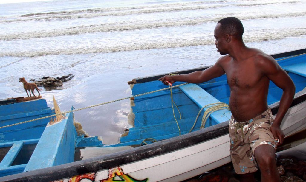 DAMAGED: A fisherman points to the damage done to a fishing pirogue when another boat collided with it out at sea.