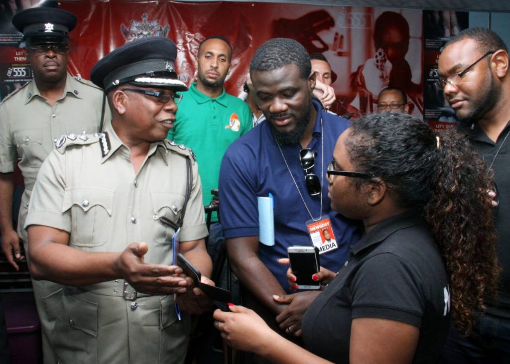 Top cop info: Acting Police Commissioner Stephen Williams shows reporters images of a man killed in a shootout with an officer in Arima yesterday at Police Administration Building, Port of Spain. Williams earlier said the Carnival threat is still alive. Photo by Angelo Marcelle