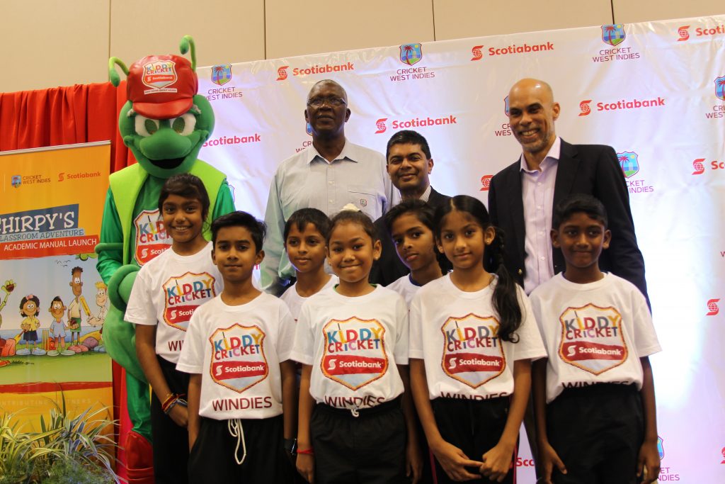 (Back row left to right) Kiddy Cricket mascot Chirpy; former West Indies player Joel Garner, CWI ambassador; Reshard Mohammed, Scotiabank VP; and director of cricket at CWI, former West Indies player Jimmy Adams pose with youngsters yesterday at the launch of Scotia’s Kiddy Cricket Academic Manual at the Hyatt Regency, PoS. PHOTO BY RATTAN JADOO
