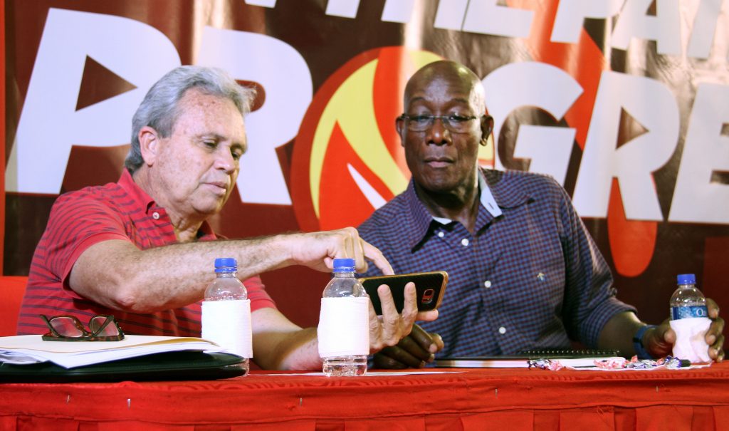 IT’S LIKE THIS: Finance Minister Colm Imbert shows something to Prime Minister Dr Keith Rowley on his cellphone during a PNM meeting at the Central Diego Martin community centre at Wendy Fitzwilliam
Boulevard on Thursday night.    PHOTO BY SUREASH CHOLAI
