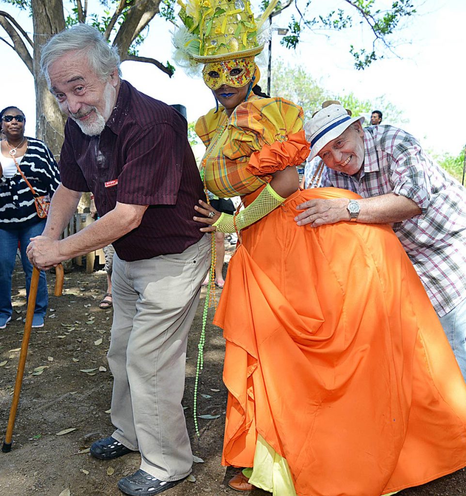 Dame Lorraine wine: Tourist (L) Dr Martin Biggs and Graham Biggs 
 visiting Nelson Island heritage site were delighted as traditional carnival artist performed before them on the Island as part of the Nelson Island carnival tour
PHOTO BY AZLAN MOHAMMED