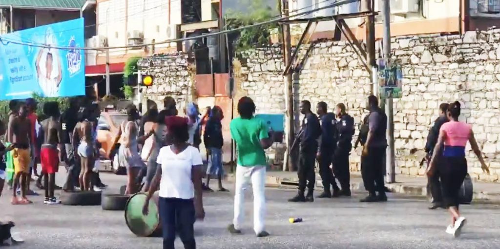 FACE-OFF: This freeze frame, taken from a video posted to social media, shows enraged people facing off with police yesterday as residents of East PoS yesterday (Monday) faced off with police in protest over the death of Akeil 'Christmas' James, who was shot by police.  