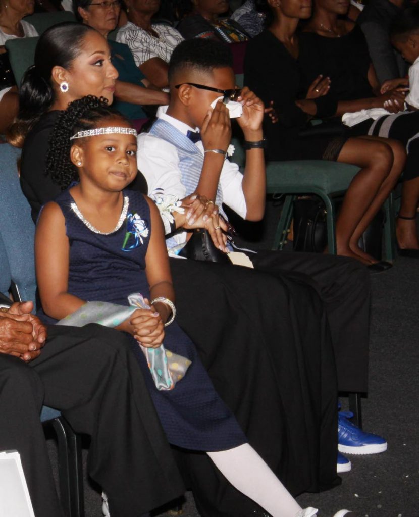 Zoe and Zion sit next to their mother Pete-Ann Bartholomew at the funeral for their father Chevonne Bartholomew who died during a diving expedition last month.