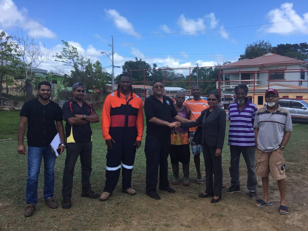 Terry Rondon, centre, Chairman of the Sangre Grande Regional Corporation, shakes the hand of a representative from Southern Sales during a site visit to the Fishing Pond Recreation Ground ahead of the installation of floodlights.