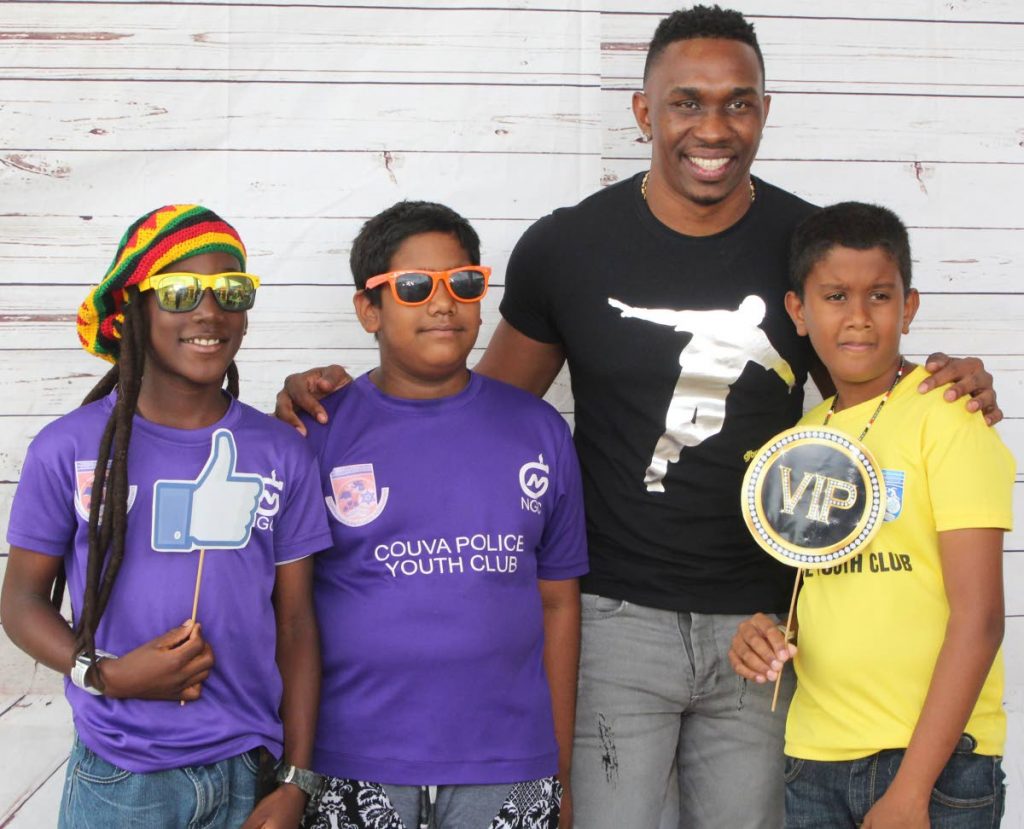 TT cricketer Dwayne Bravo poses for a photo with youngsters of the Couva Police Youth Club, on Saturday, at the Five Islands amusement park, Chaguaramas during a meet and greet. Bravo urged the youth to set goals early in life.