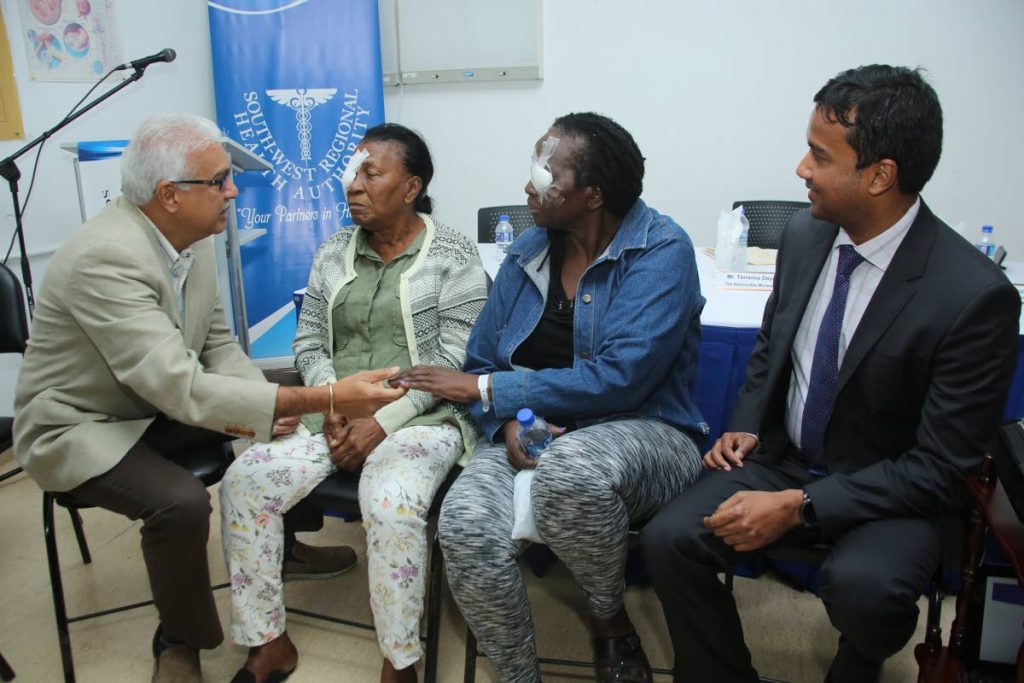 Health Minister Terrance Deyalsingh interacts with cataract patients, Evelyn and Beulah Thompson, while Dr Anil Armoogum, head of the Ophthalmology Department of the South West Regional Health Authority, looks on. The minister was at the San Fernando General Hospital after a number of cataract surgeries were done as part of an initiative to clear the backlog of such cases. PHOTO BY VASHTI SINGH