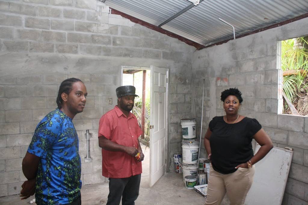Digicel Foundation’s operations manager Cindyann Currency  and president of the 
Antillean All Stars Jerod Williams, centre,and a member of the band observe the ongoing 
project at the Antilleans’ All Stars panyard.