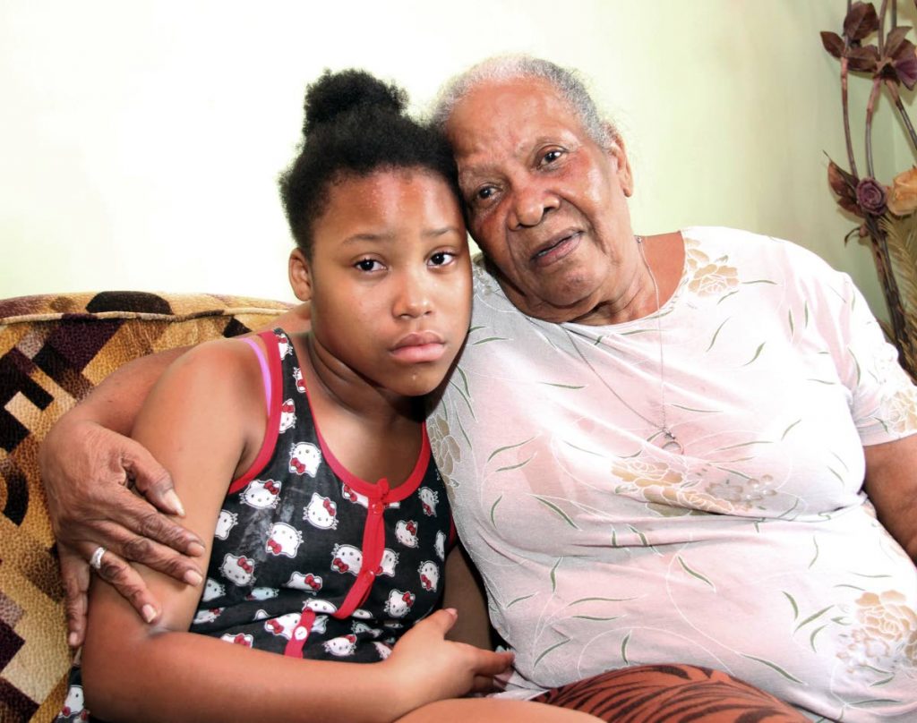 Grandmom Ida Armstrong consoles Kelis Armstrong the daughter of Melissa Tricia Emananuel ,the woman who was killed on Friday night inside a taxi during a robbery on Wrightson  Road , Port of Spain  .( at her home on Mt Pleasant Road Arima)