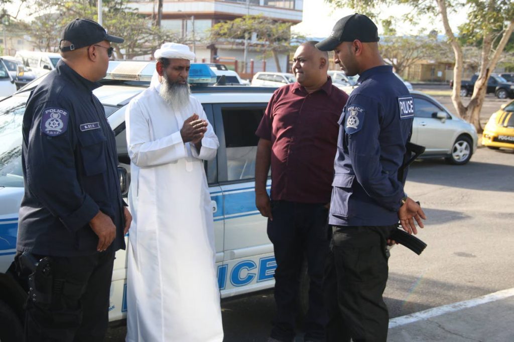 DEFENDING THE POLICE: Islamic Front  Leader Umar Abdullah speaks with police officers at the rally in Marabella on Sunday after accusing other Muslim groups of antagonising the police.     PHOTO BY ANSEL JEBODH