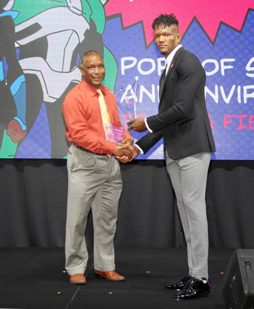 Kelvin Nancoo, left, is presented with the the Coach of the Year and Team of the Year ( for Port of Spain and Environs) awards by Olympic Gold Medalist Keshorn Walcott, at the fouth annual Atlantic Youth Excellence in Sports (YES) Awards at Hilton Trinidad, Port of Spain yesterday.