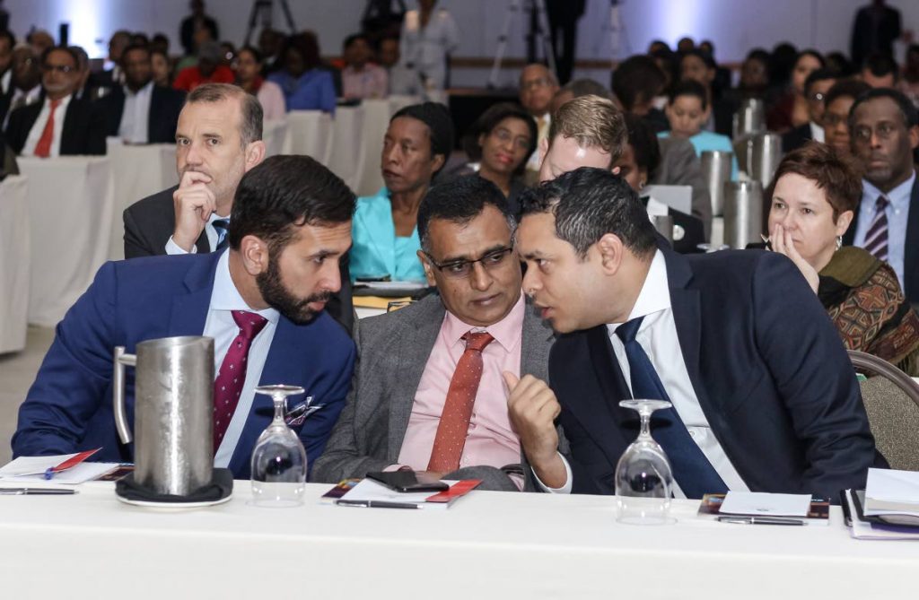 SHOO-SHOOING: Attorney General Faris Al-Rawi, left, and Works and Transport Minister Rohan Sinanan listen to a point made by Housing Minister Randall Mitchell at the Spotlight on Energy conference last week at the Hyatt Regency in Port of Spain. PHOTO BY JEFF K. MAYERS