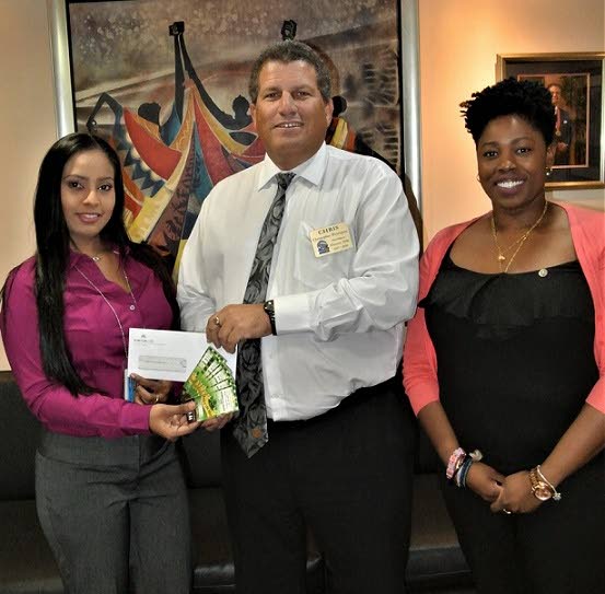 ANSA McAL presents cheque to Rotary Club of Port of Spain for its Arrow Literacy Program: (Left) Natasha Ramnath, ANSA McAL Group Corporate Communication Officer,presents a cheque to Christopher Henriques, President of the Rotary Club of Port of Spain, West  as she receives tickets to the Club’s Annual Poor
Man’s Dinner and Dance. Also in photo (right) is Cindy-Ann Currency, member of the Rotary Club of Port of Spain, West. PHOTO COURTESY ANSA MCAL.