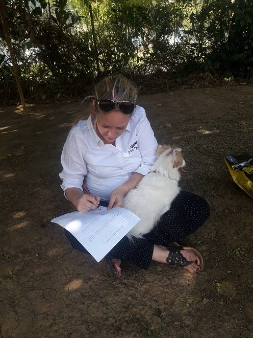Dr Emily Cappon, a vet at Sunnyview Veterinary Clinic in Diego Martin, completes nutritional instructions for a dog (on her lap) during the February edition of Fun in the Park event, held at Tenderheart Veterinary Services, St Augustine. PHOTO COURTESY TENDERHEART VET CLINIC.