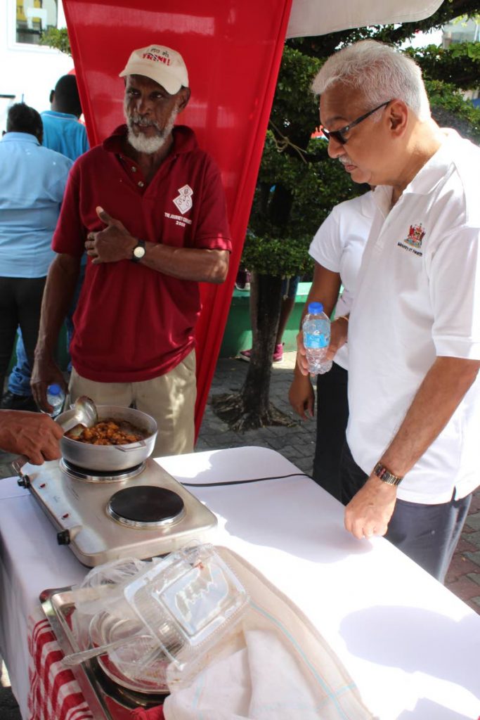 What's cooking?: Health Minister Terrence Deyalsingh takes careful note of a dish being cooked at the NWRHA Care Fair, San Juan Promenade, Croisee yesterday. PHOTO BY ENRIQUE ASSOON