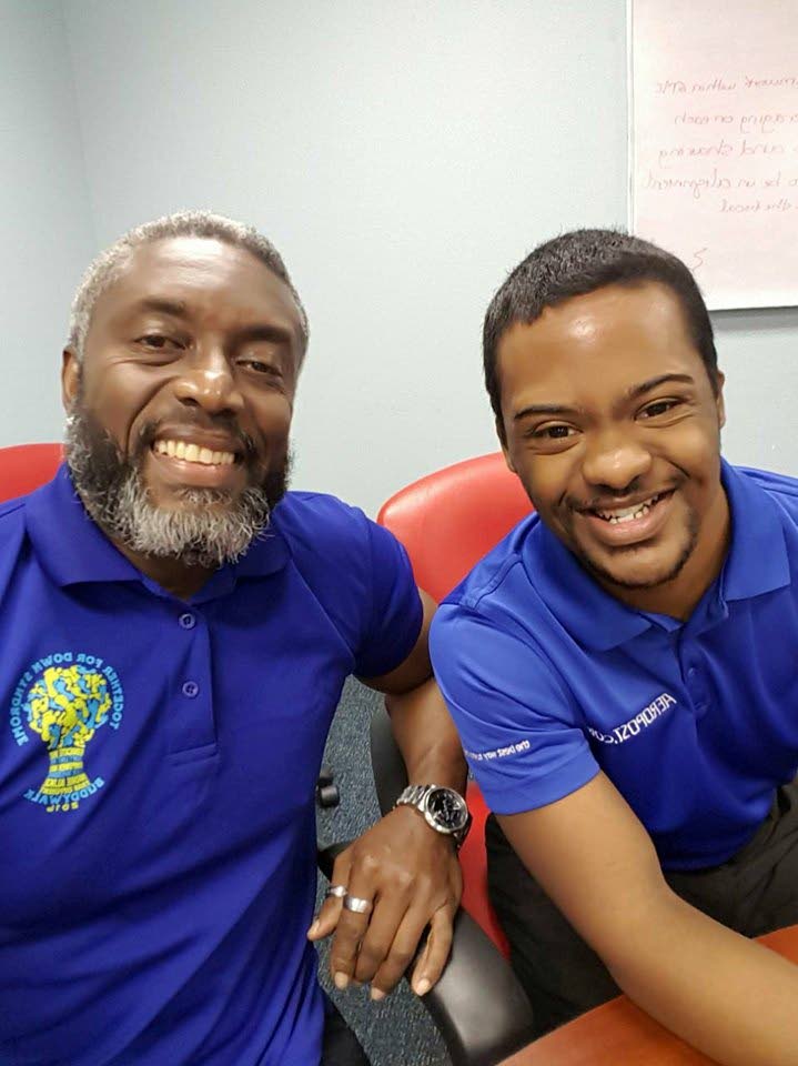 Glen Niles (left) chairman of the Down Syndrome Family Network is all smiles with his son, Tyrese Niles (right). 
