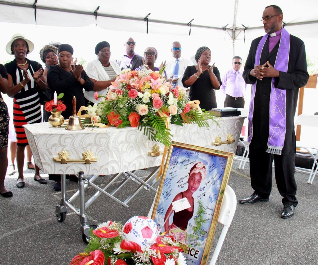 WORDS OF COMFORT: Bishop Christopher Henry speaks to mourners at the funeral for murder victim Michaela Mason at the Sobo Village recreation ground in La Brea yesterday. PHOTO BY ANIL RAMPERSAD