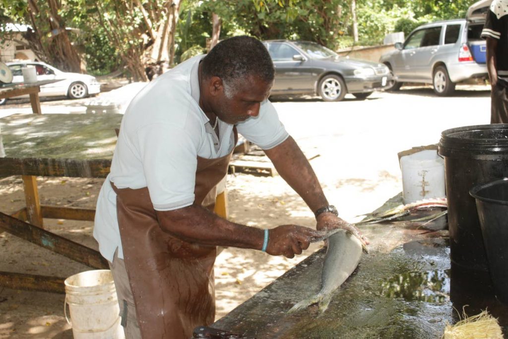 A Pigeon Point fisherman cleans fish for sales to residents 